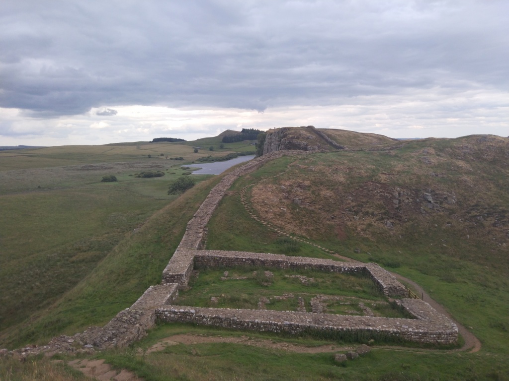 View of cliffs, a milecastle ruin and Hadrian's Wall, near Once Brewed 